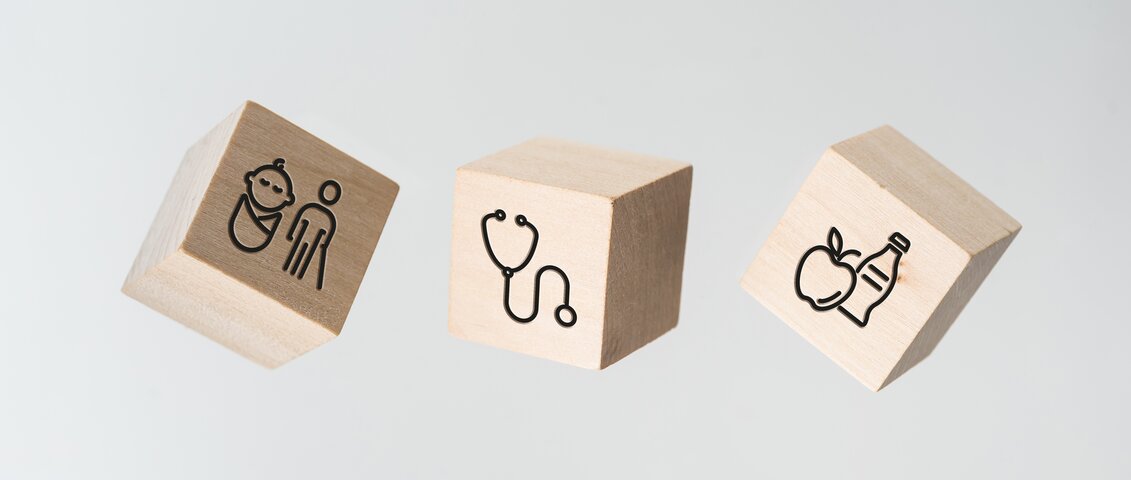 Drei Würfel mit Symbolen zu Benefits am Arbeitsplatz